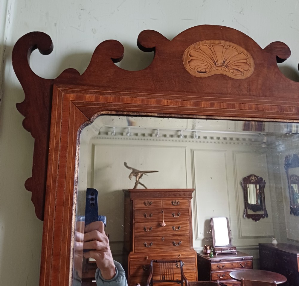 An Edwardian mahogany fretwork wall mirror featuring a scrolled frame with shell inlay details at the top and bottom. View III