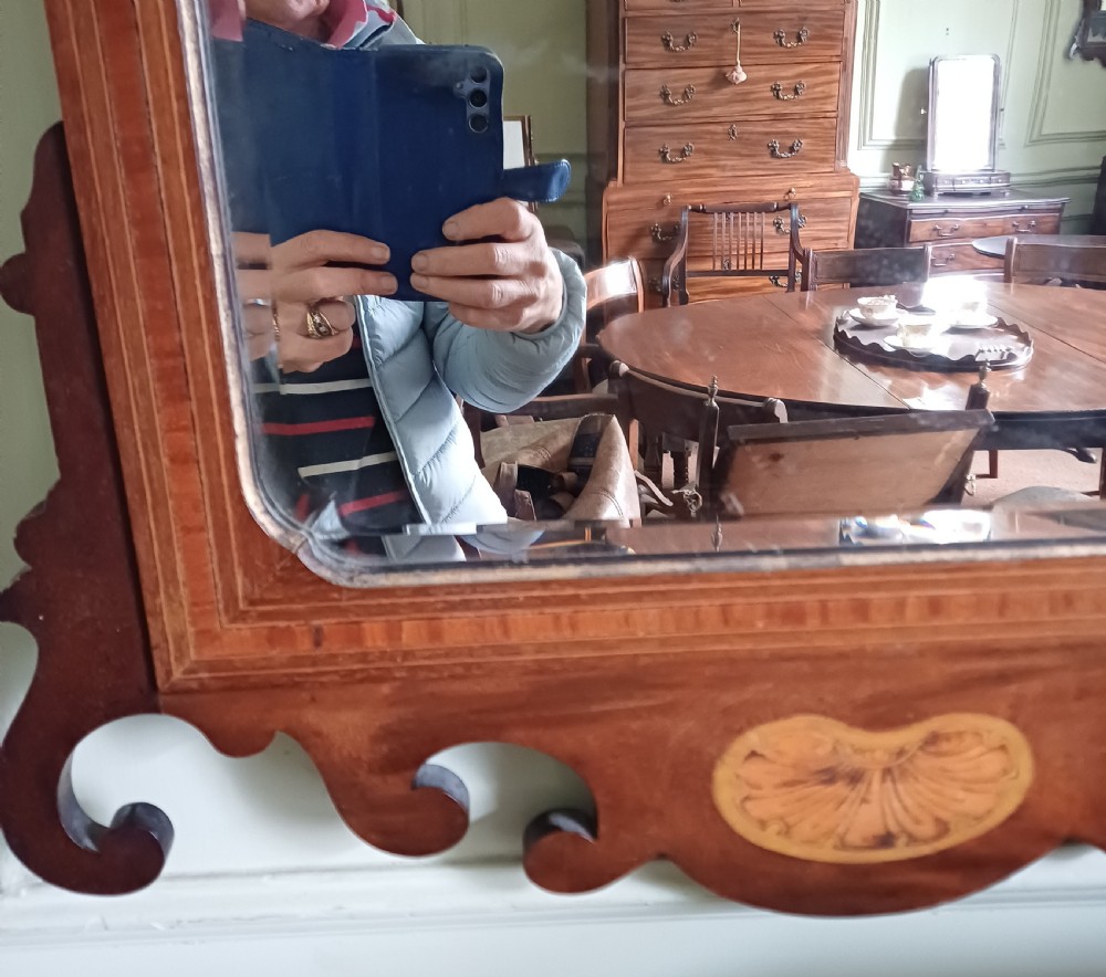 An Edwardian mahogany fretwork wall mirror featuring a scrolled frame with shell inlay details at the top and bottom. View IV