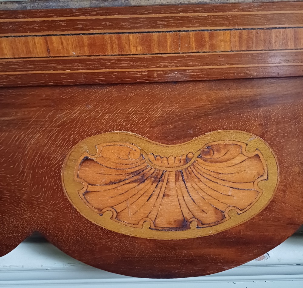 An Edwardian mahogany fretwork wall mirror featuring a scrolled frame with shell inlay details at the top and bottom. View V