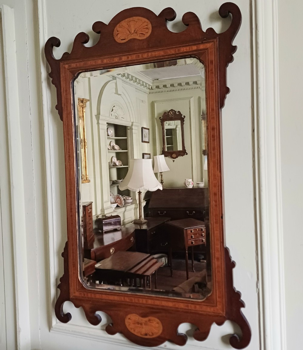 An Edwardian mahogany fretwork wall mirror featuring a scrolled frame with shell inlay details at the top and bottom. View VI
