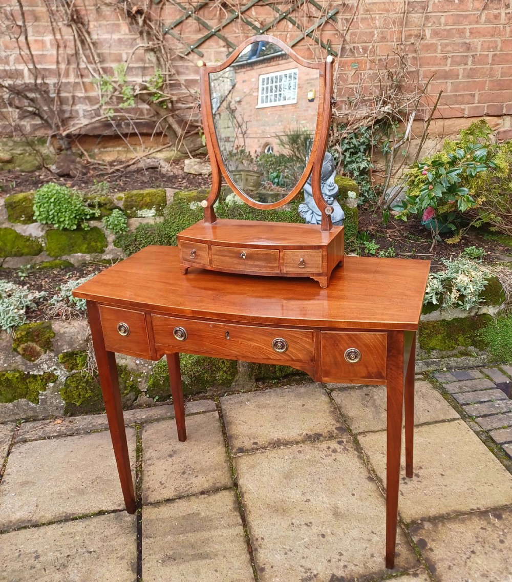 A nineteenth-century mahogany writing table featuring a central drawer flanked by two side drawers with brass ring handles, supported on slim tapered legs. View VIII