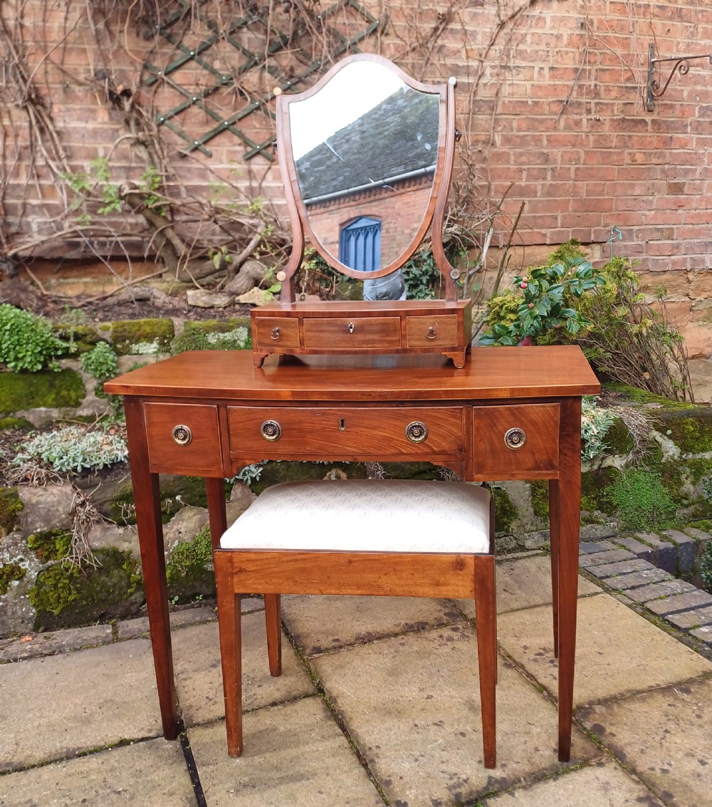 A nineteenth-century mahogany writing table featuring a central drawer flanked by two side drawers with brass ring handles, supported on slim tapered legs. View IX