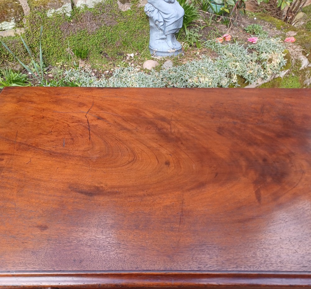 A small Georgian mahogany chest of drawers featuring four graduated drawers, brass swan-neck handles, a pull-out brushing slide, and bracket feet. View VIII