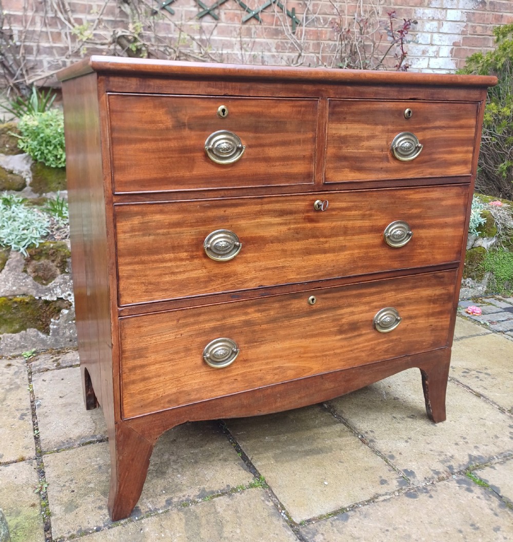 A small Regency mahogany chest of drawers with two short drawers over two long drawers, fitted with brass oval handles and supported on splayed bracket feet. View III