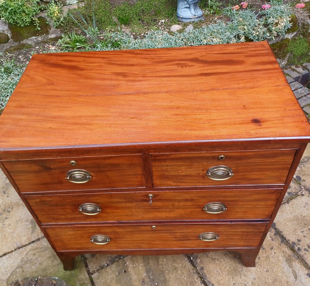 A small Regency mahogany chest of drawers with two short drawers over two long drawers, fitted with brass oval handles and supported on splayed bracket feet. View VII