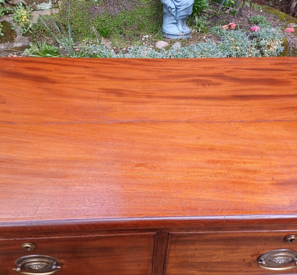 A small Regency mahogany chest of drawers with two short drawers over two long drawers, fitted with brass oval handles and supported on splayed bracket feet. View VIII