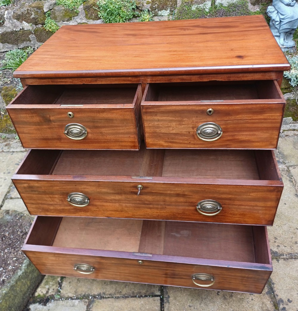 A small Regency mahogany chest of drawers with two short drawers over two long drawers, fitted with brass oval handles and supported on splayed bracket feet. View IX
