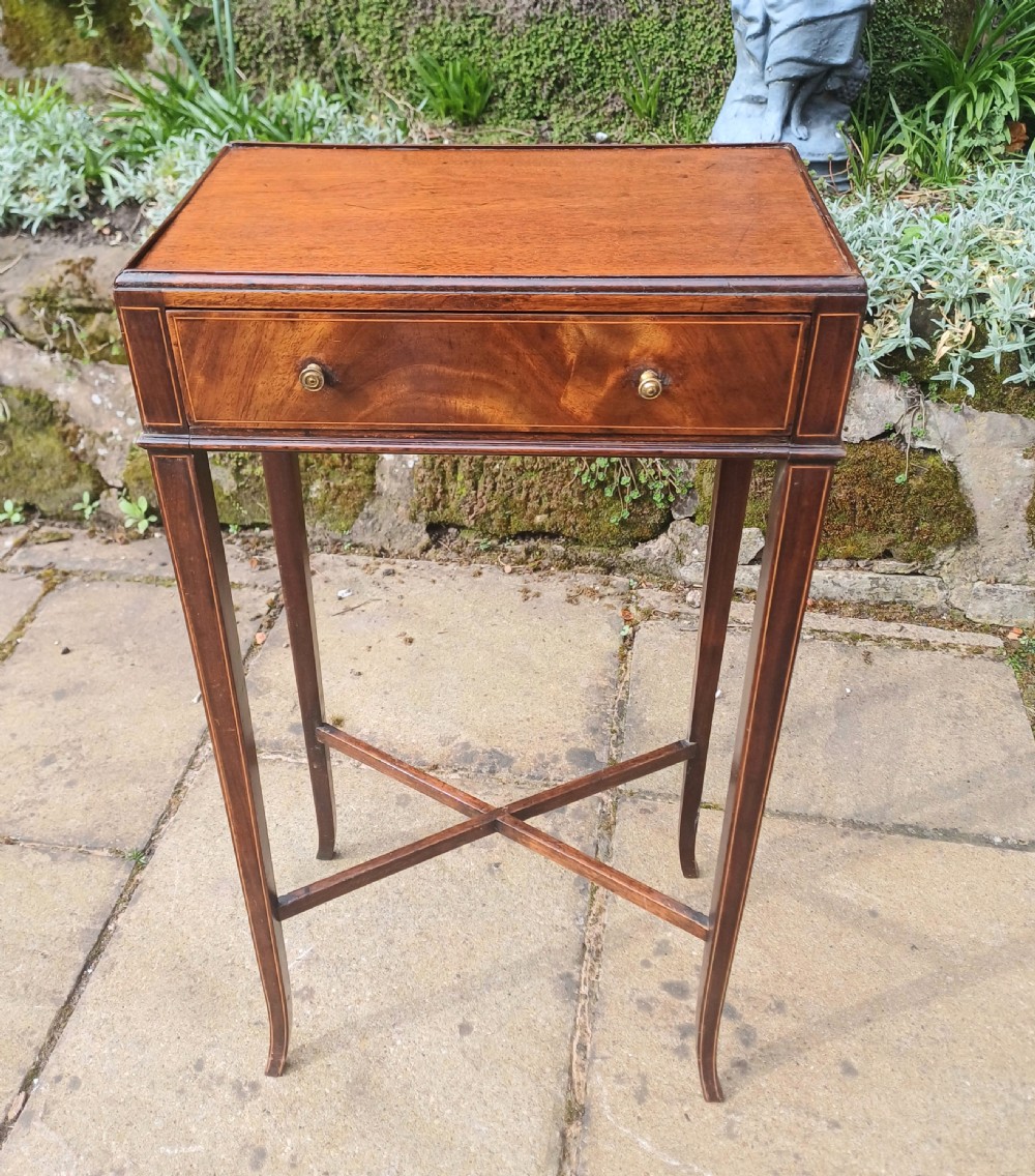 An antique Georgian mahogany side table featuring fine boxwood inlay, a single drawer with twin brass knobs, tapered legs, and an X-frame stretcher.