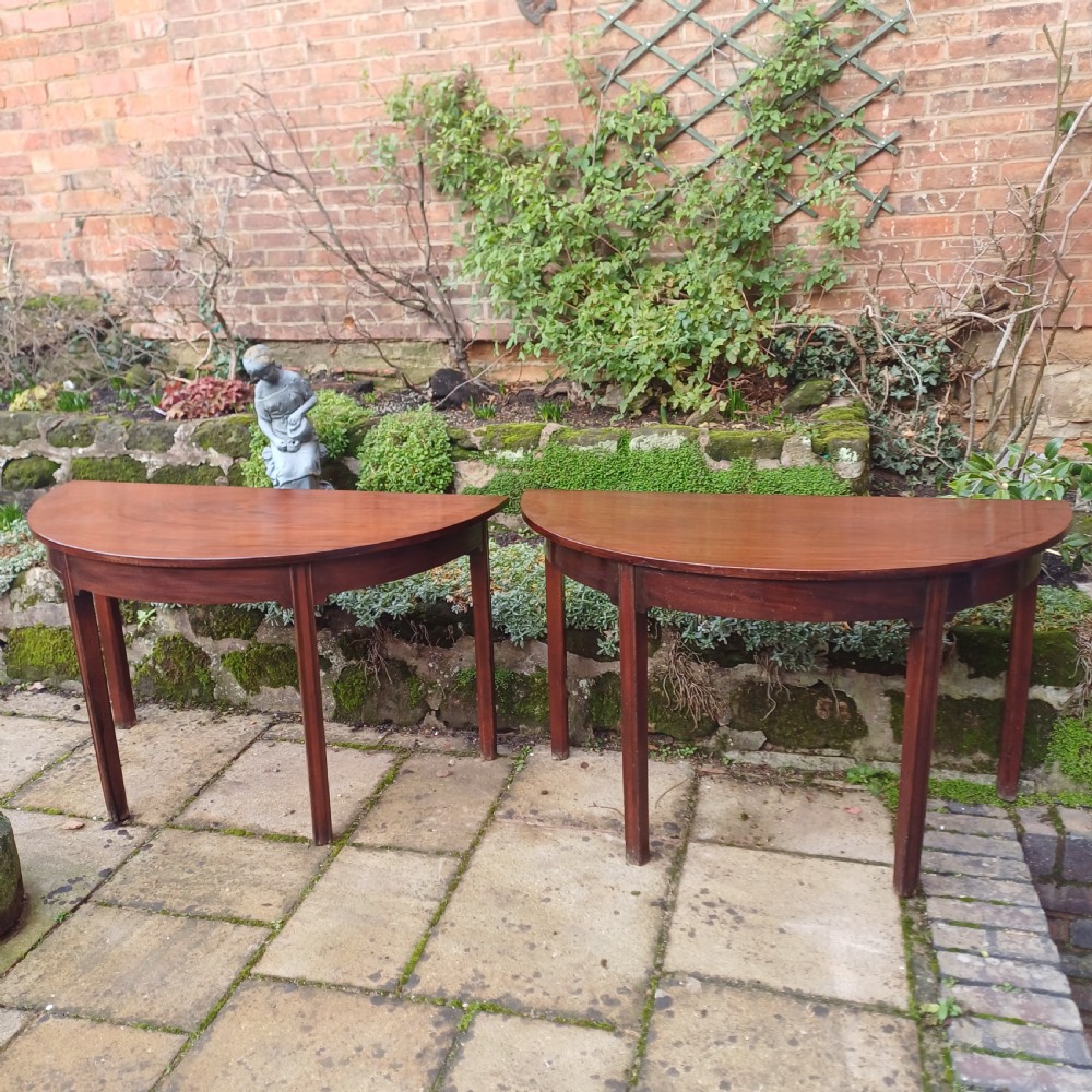 A pair of Georgian mahogany demi-lune tables with semi-circular tops and straight tapered legs. View II