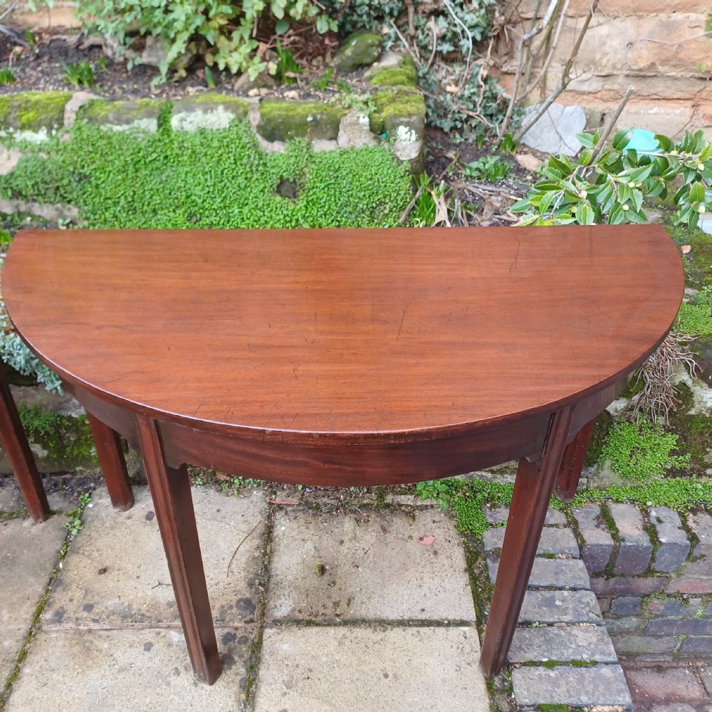 A pair of Georgian mahogany demi-lune tables with semi-circular tops and straight tapered legs. View V