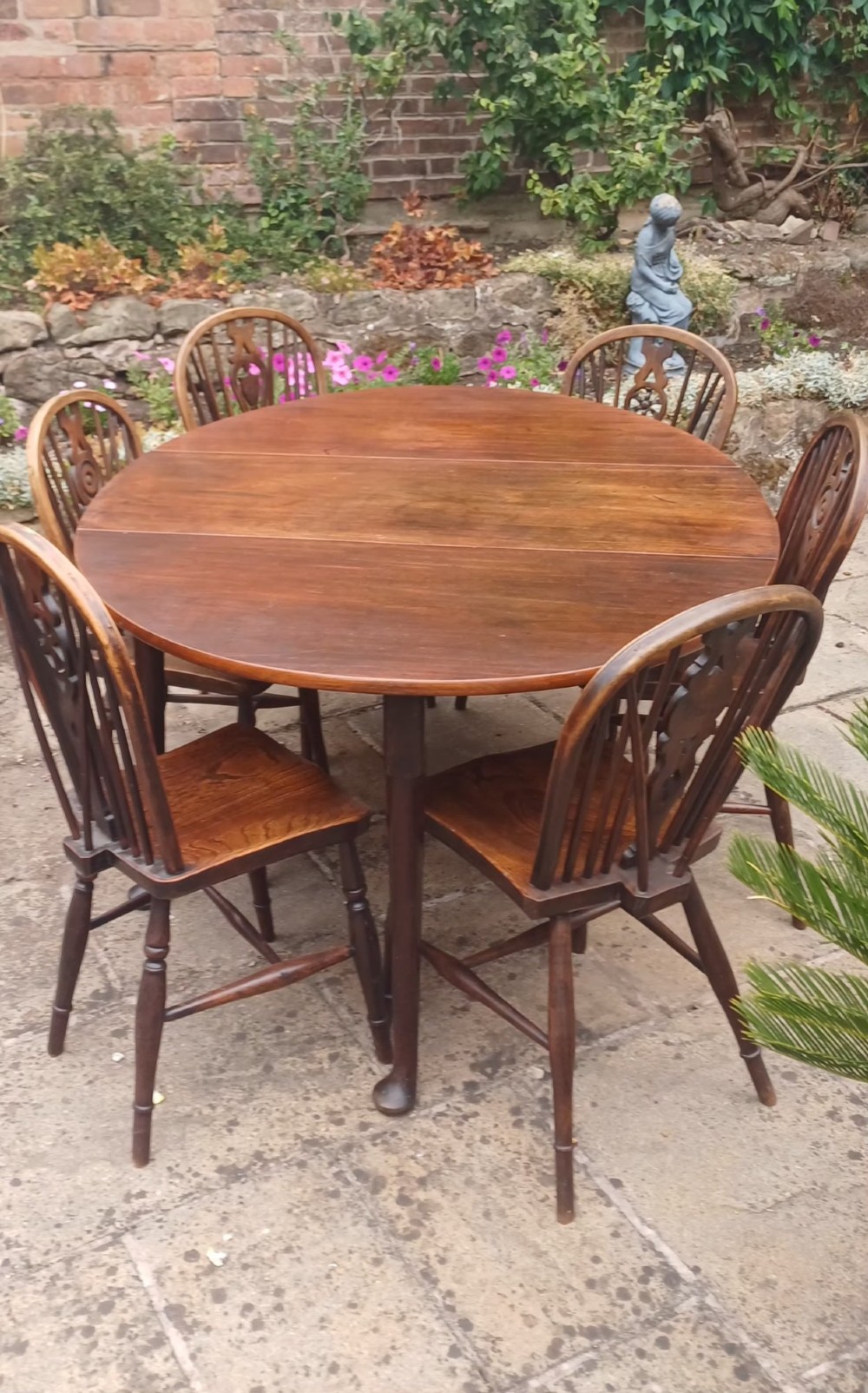 A dark mahogany Georgian drop-leaf dining table with two hinged side leaves resting on tapered legs with pad feet. View VI