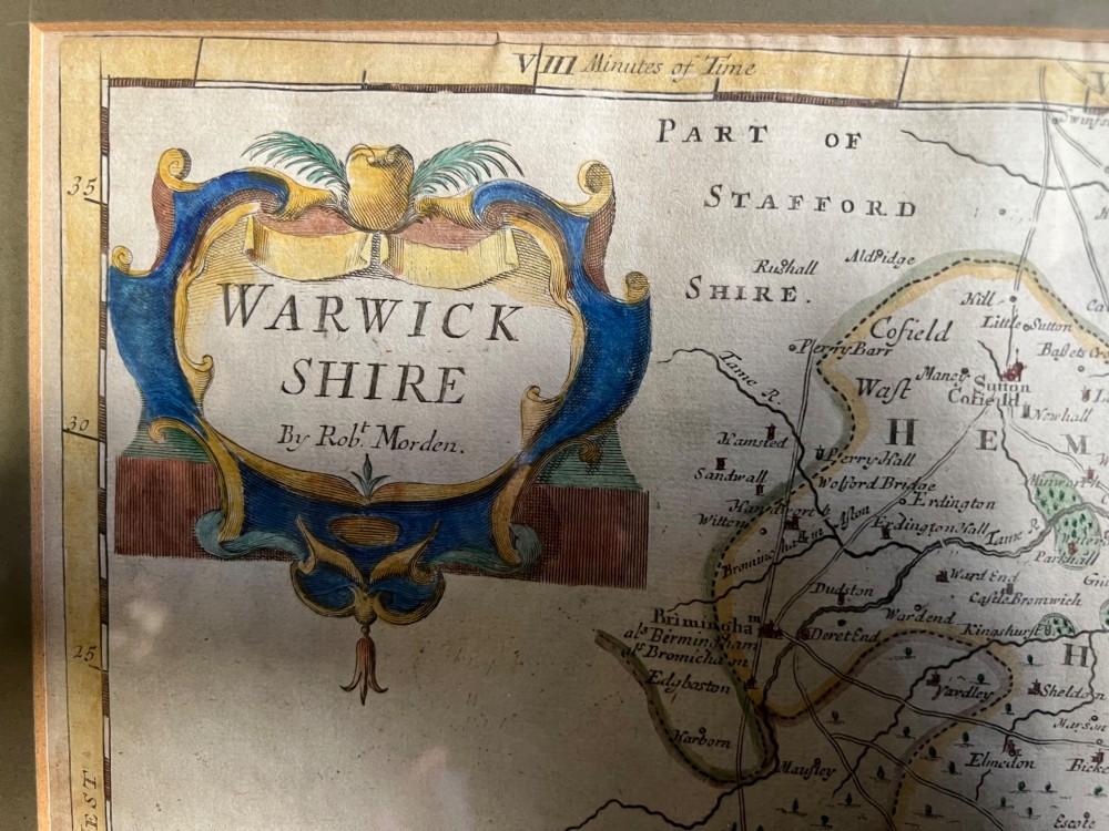 A framed 17th-century hand-coloured map of Warwickshire by Robert Morden set in a wide grey mount with a gilt frame. View II