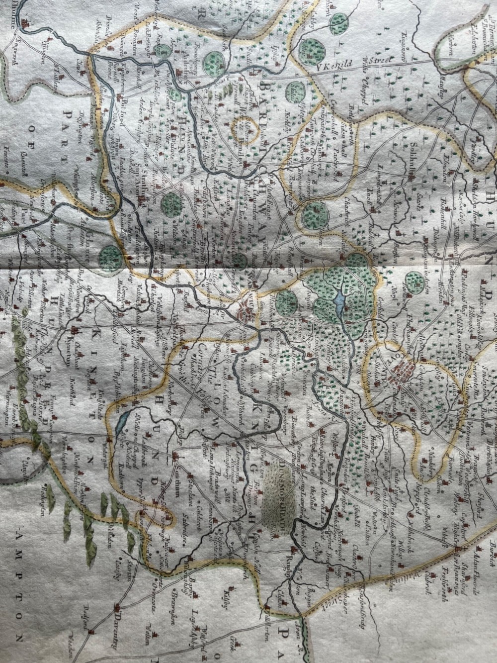 A framed 17th-century hand-coloured map of Warwickshire by Robert Morden set in a wide grey mount with a gilt frame. View IV