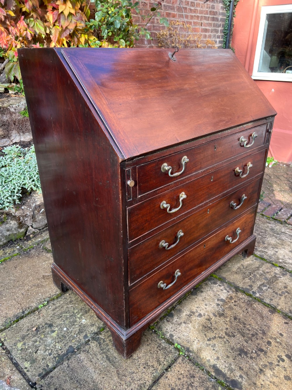 An 18th-century Georgian mahogany bureau with a slant-front writing lid above four long graduated drawers fitted with brass swan-neck handles. View VII