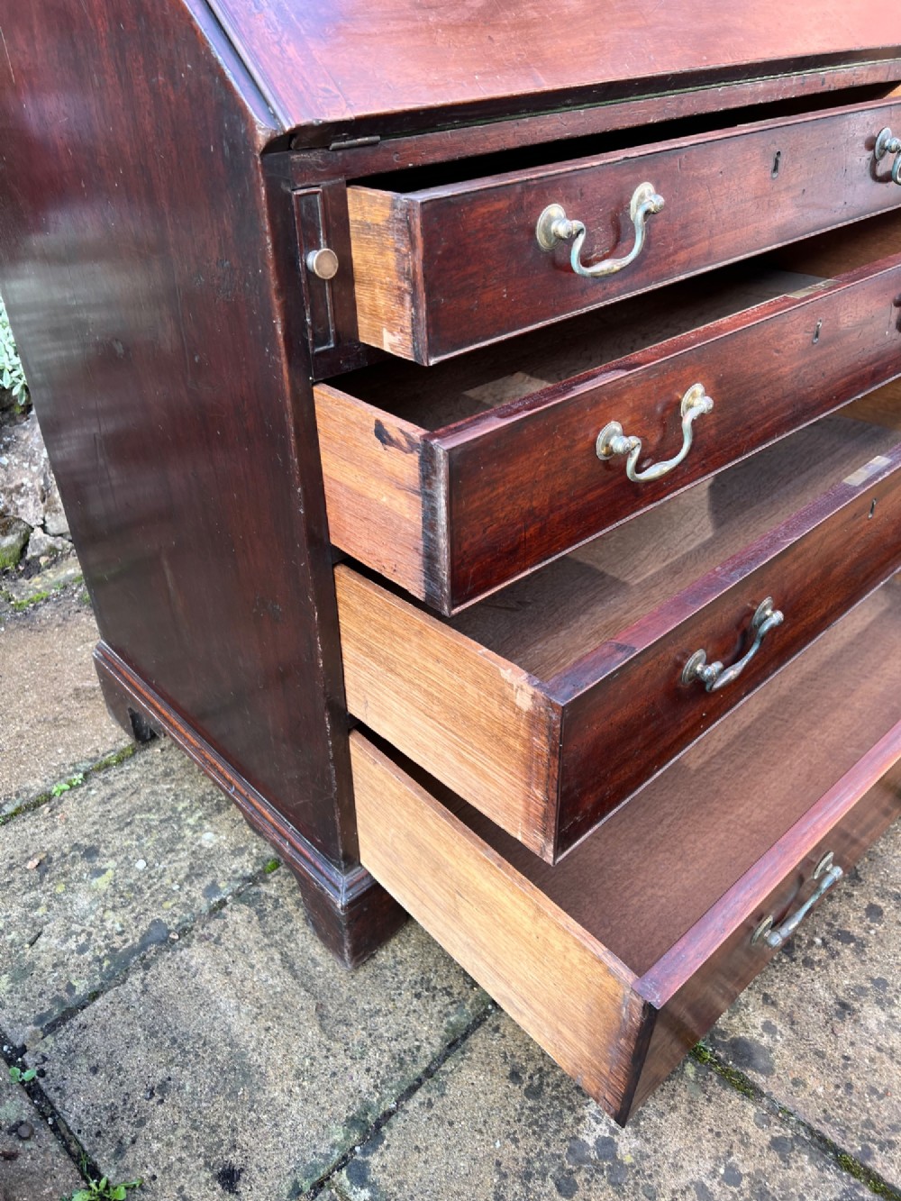 An 18th-century Georgian mahogany bureau with a slant-front writing lid above four long graduated drawers fitted with brass swan-neck handles. View VIII
