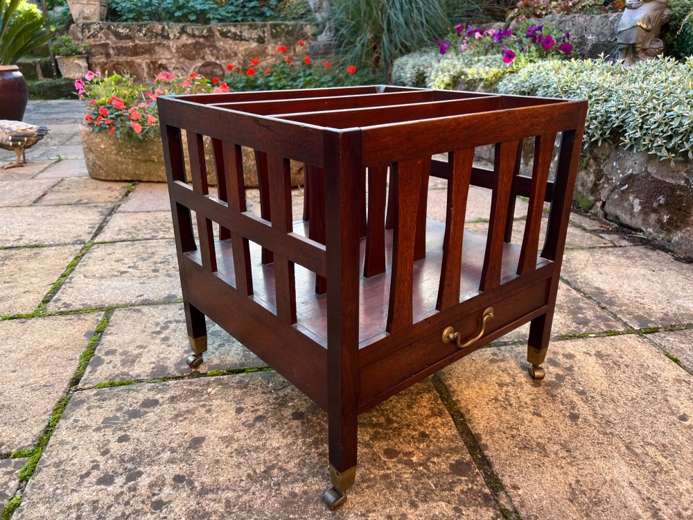An eighteenth-century mahogany Canterbury featuring slatted vertical dividers, a single lower drawer with a brass handle, and four legs with brass castors. View II