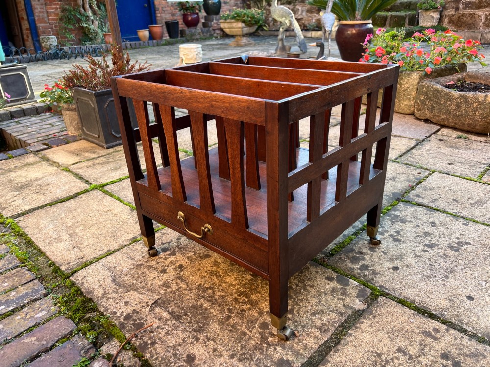 An eighteenth-century mahogany Canterbury featuring slatted vertical dividers, a single lower drawer with a brass handle, and four legs with brass castors. View III