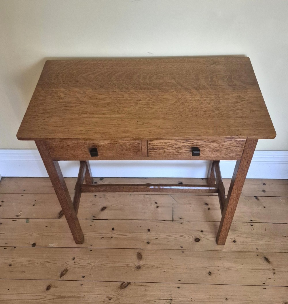 A medium brown antique oak side table featuring two drawers with dark square knobs, straight square legs, and an H-stretcher base. View III