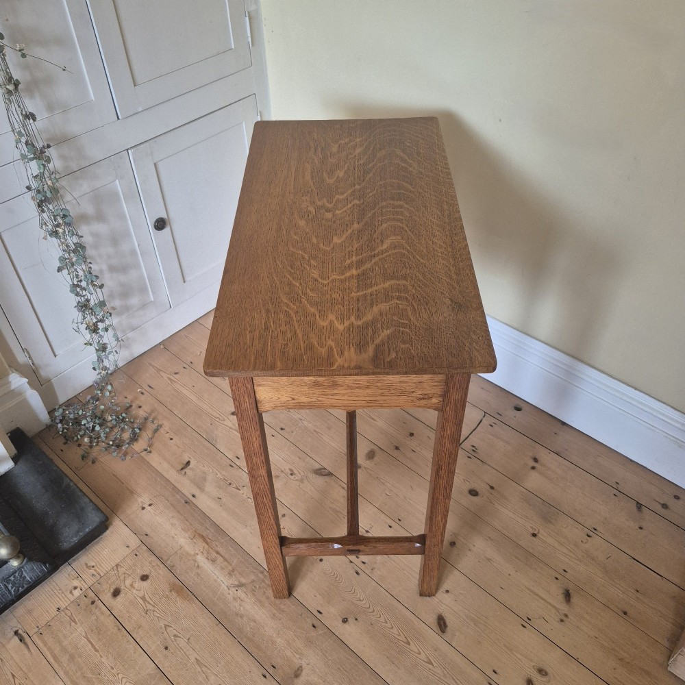A medium brown antique oak side table featuring two drawers with dark square knobs, straight square legs, and an H-stretcher base. View VI