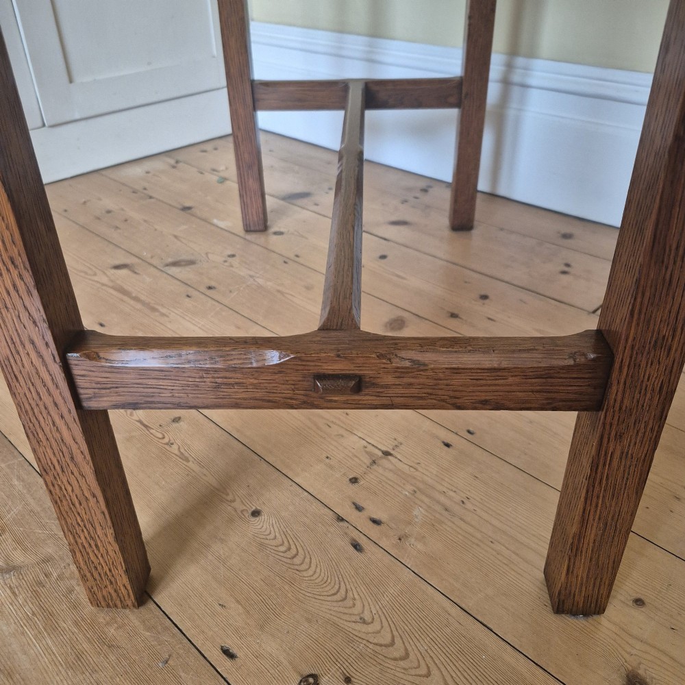 A medium brown antique oak side table featuring two drawers with dark square knobs, straight square legs, and an H-stretcher base. View VII