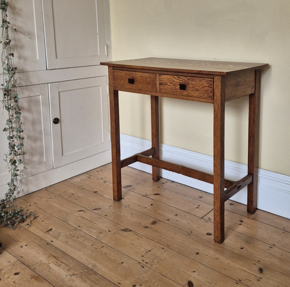 A medium brown antique oak side table featuring two drawers with dark square knobs, straight square legs, and an H-stretcher base. View VIII
