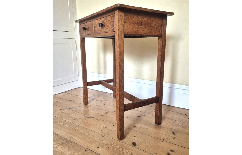 A medium brown antique oak side table featuring two drawers with dark square knobs, straight square legs, and an H-stretcher base. View IX