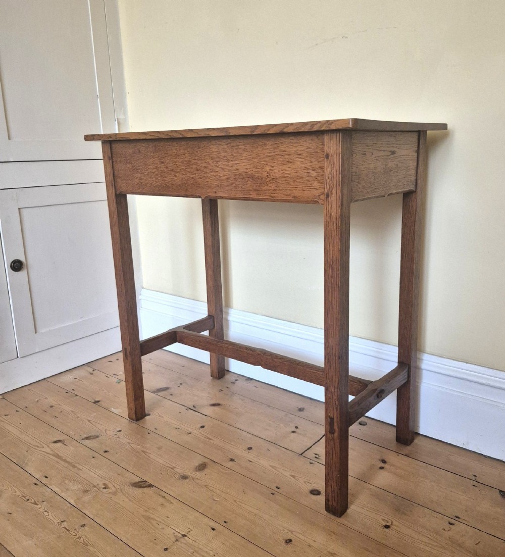 A medium brown antique oak side table featuring two drawers with dark square knobs, straight square legs, and an H-stretcher base. View XI