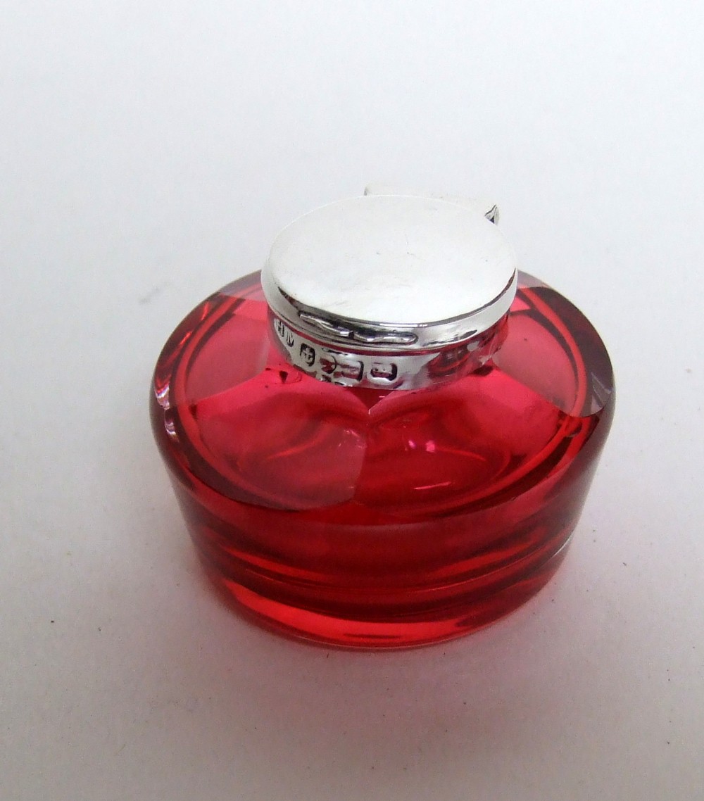 A charming early Victorian silver and cranberry ink bottle.
