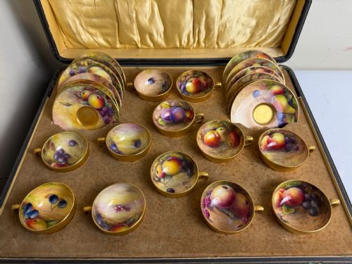 fig 2. An open fitted presentation case containing twelve hand-painted porcelain demitasse coffee cups and saucers decorated with fruit motifs and gilded interiors.