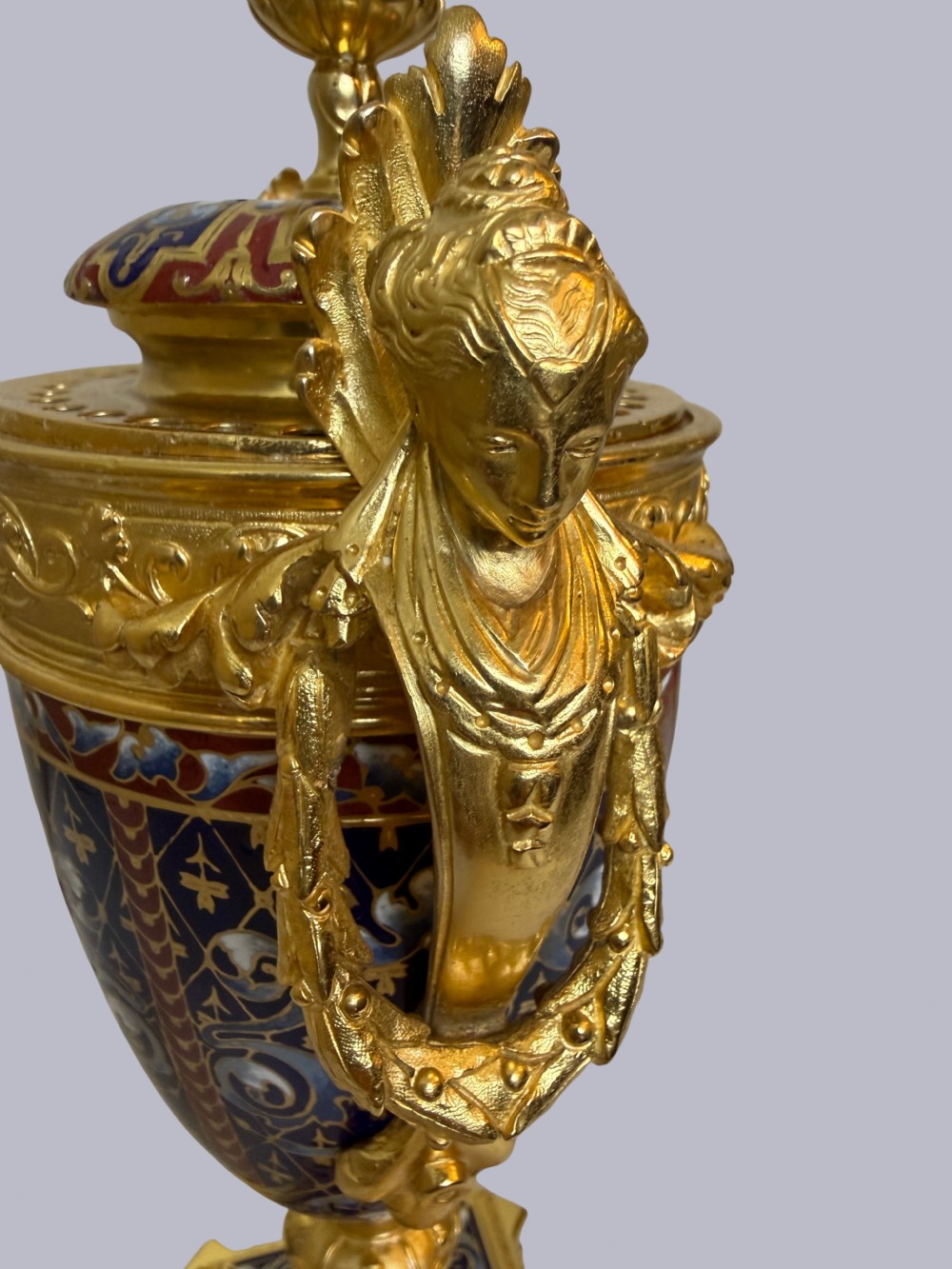 A 19th-century French lidded urn crafted from gilt bronze featuring blue and red champleve enamel detailing with figural handles and a finial lid. View III