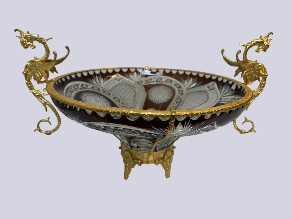 A deep red and clear cut glass bowl featuring gilt bronze dragon handles and a footed metal base. View VII