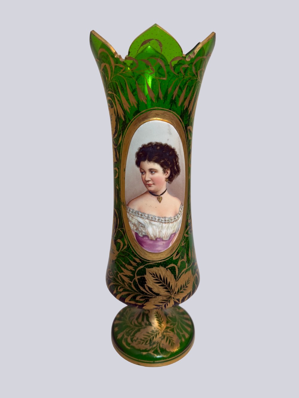 A three-piece emerald green Bohemian glass garniture set featuring gold gilt leaf patterns and oval enamel painted lady portraits. View VI