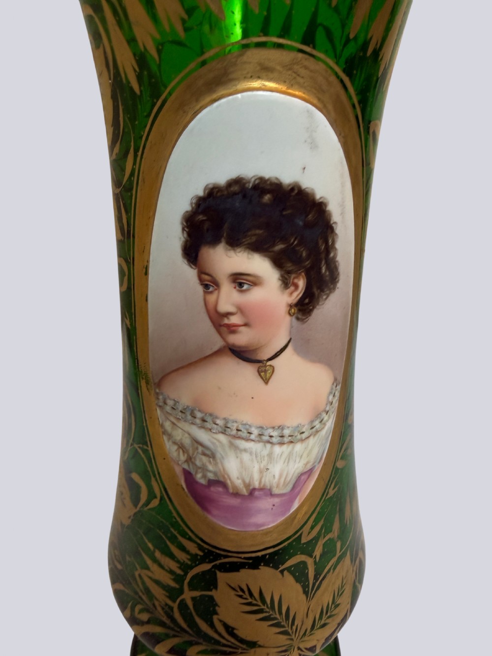 A three-piece emerald green Bohemian glass garniture set featuring gold gilt leaf patterns and oval enamel painted lady portraits. View VII