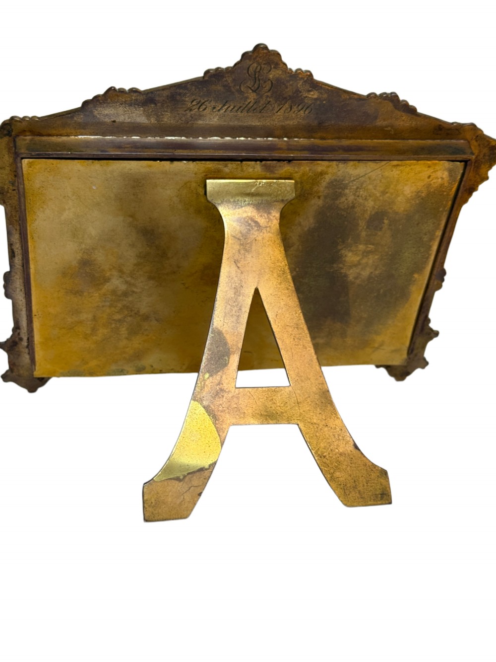 A 19th-century French gilt bronze and champleve enamel picture frame resting alongside a matching hand mirror with colourful floral motifs. View V