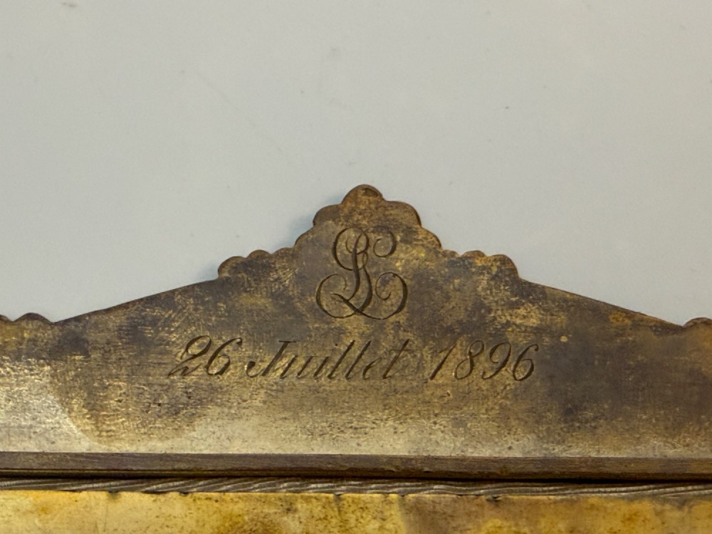 A 19th-century French gilt bronze and champleve enamel picture frame resting alongside a matching hand mirror with colourful floral motifs. View VI