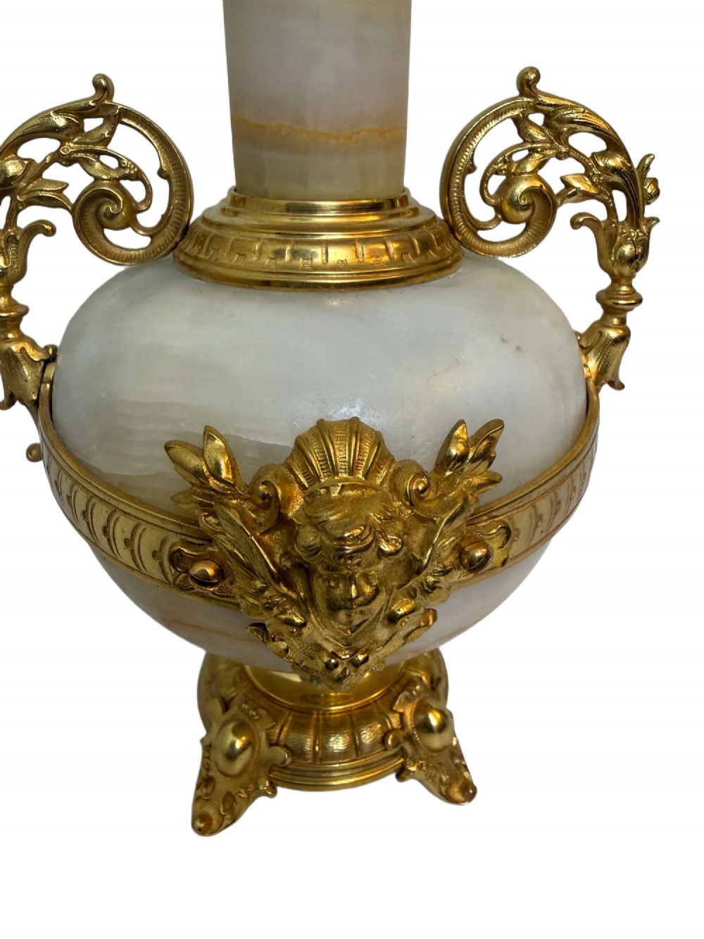 A pair of 19th-century French vases constructed from cream white veined onyx with ornate gilt bronze handles, winged cherub mounts, and footed bases. View IV