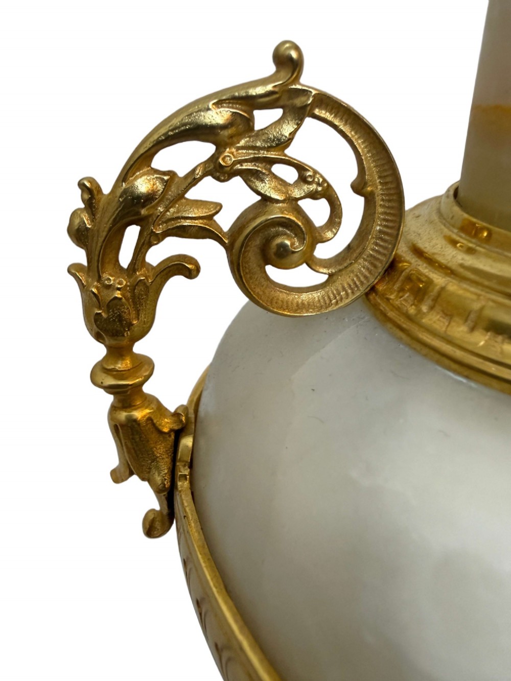 A pair of 19th-century French vases constructed from cream white veined onyx with ornate gilt bronze handles, winged cherub mounts, and footed bases. View V