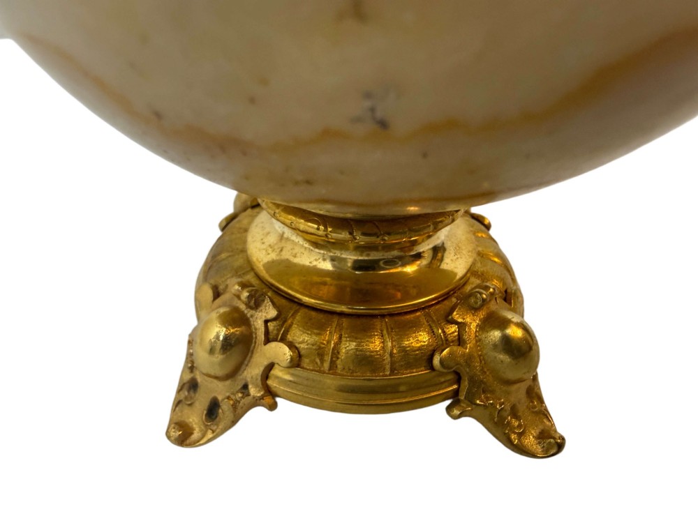 A pair of 19th-century French vases constructed from cream white veined onyx with ornate gilt bronze handles, winged cherub mounts, and footed bases. View VII