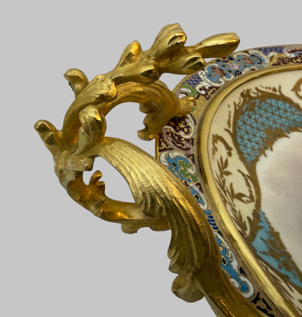 A circular 19th-century French porcelain centrepiece with hand-painted classical figures framed by colourful champleve enamel and twin gilt bronze handles. View IV