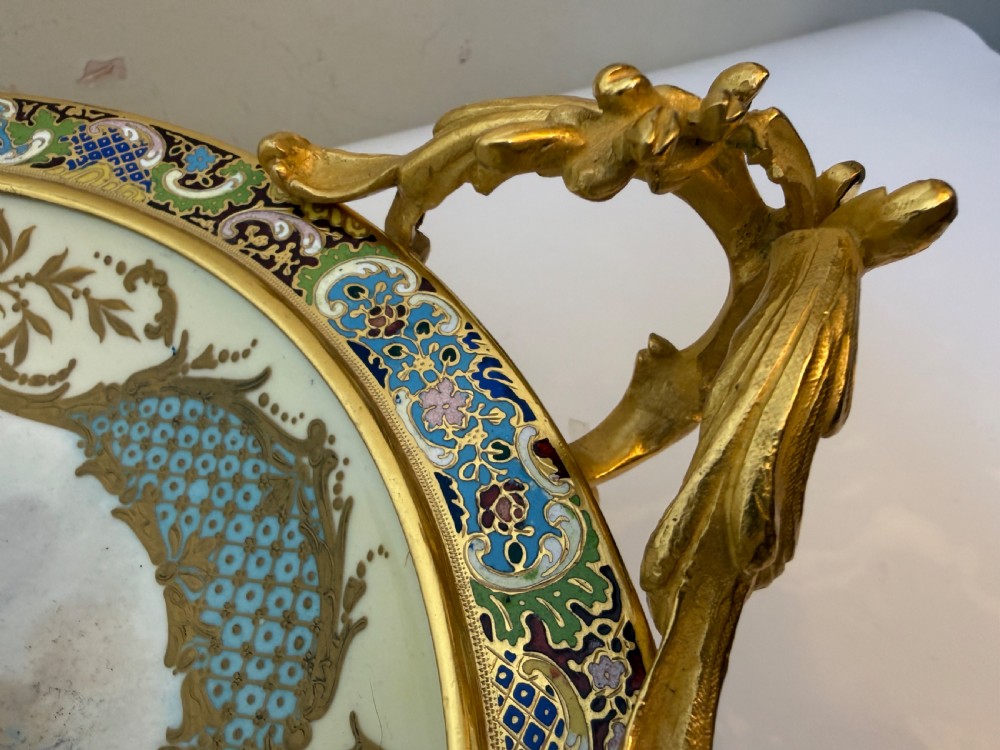A circular 19th-century French porcelain centrepiece with hand-painted classical figures framed by colourful champleve enamel and twin gilt bronze handles. View VII