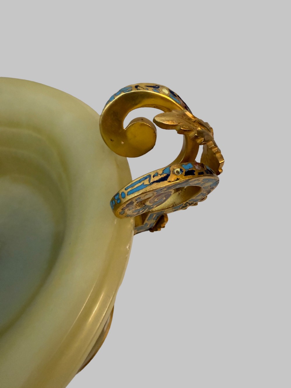 A 19th-century French green onyx centrepiece bowl on a pedestal base featuring twin scroll handles decorated with champleve enamel and gilt bronze mounts. View V