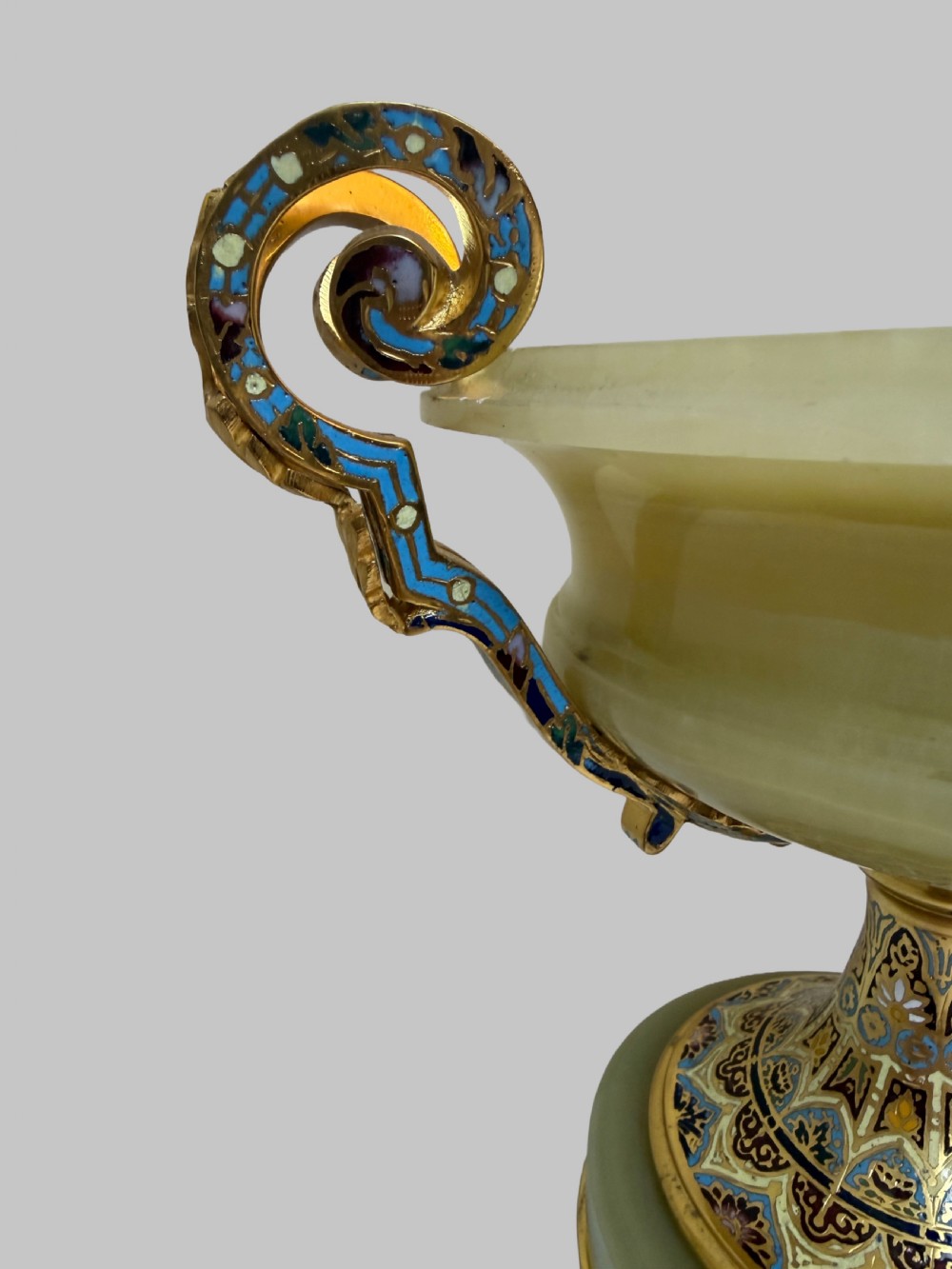 A 19th-century French green onyx centrepiece bowl on a pedestal base featuring twin scroll handles decorated with champleve enamel and gilt bronze mounts. View VI