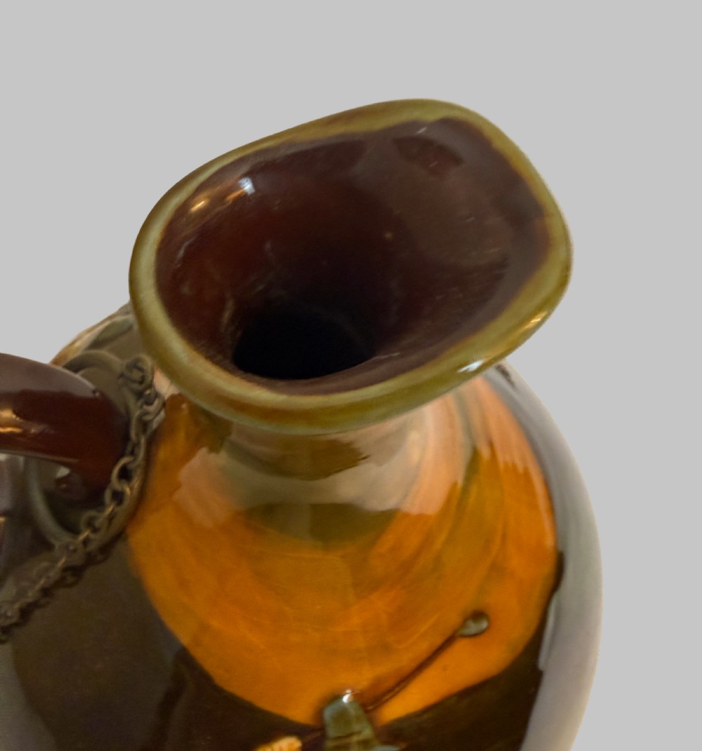 A brown and ochre glazed ceramic whisky flask featuring a raised relief figure of a golfer with an attached cork stopper on a metal chain. View III