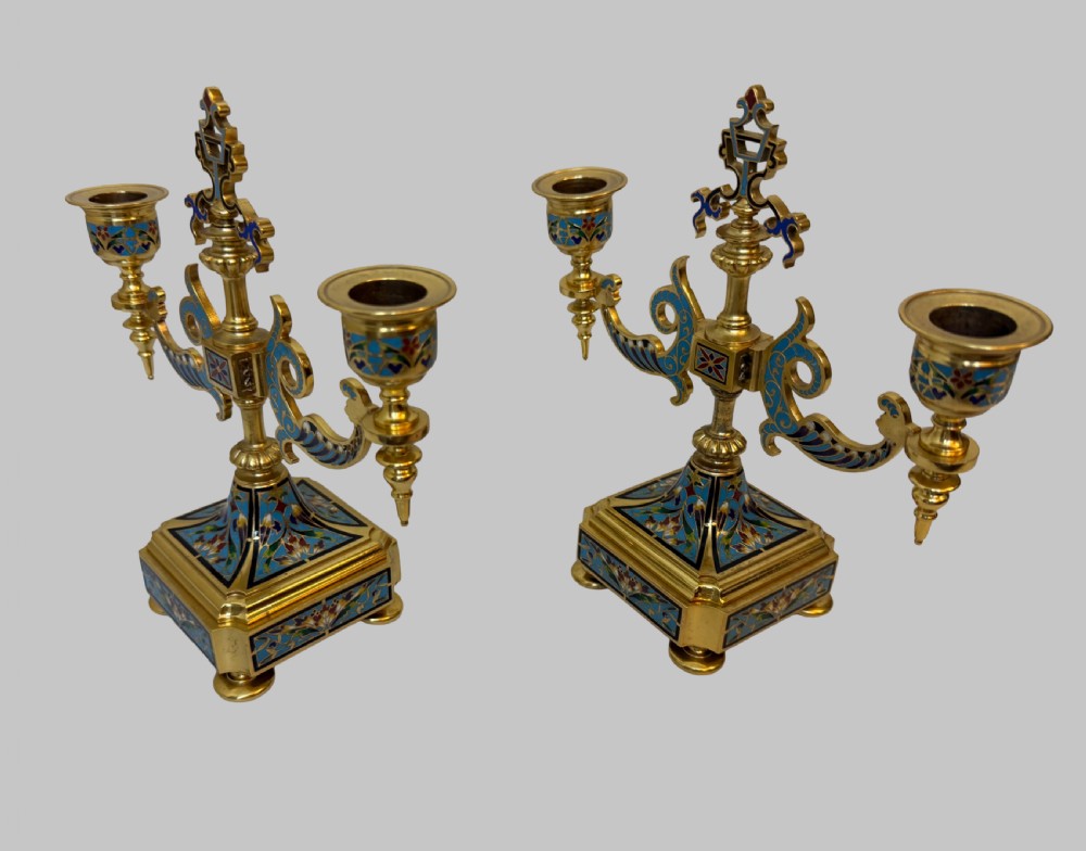 A pair of 19th-century gilt bronze two-light candelabra decorated with blue and multicoloured champleve enamel on square stepped bases.