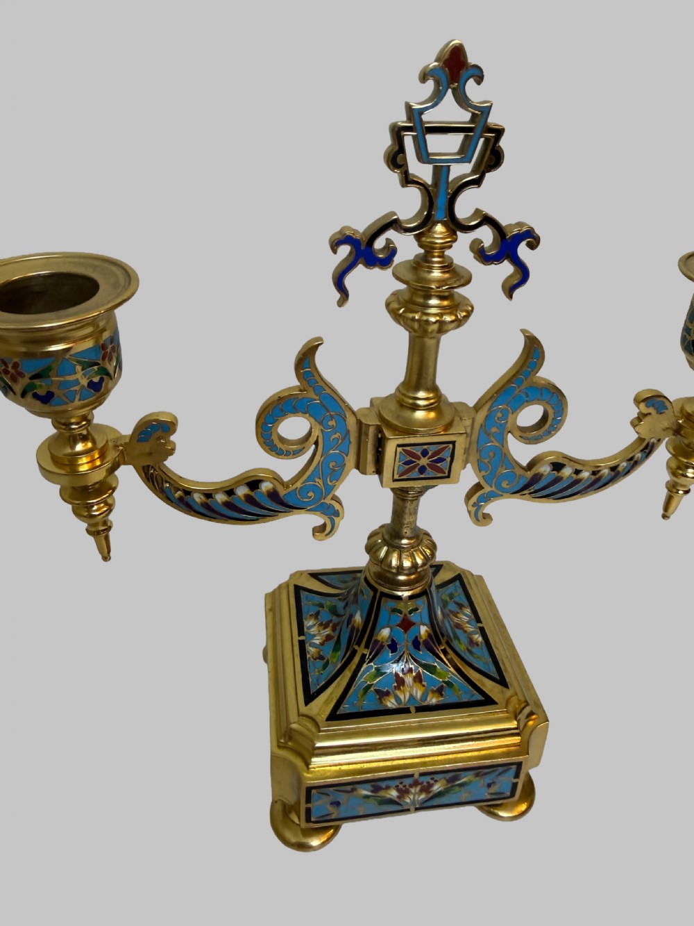 A pair of 19th-century gilt bronze two-light candelabra decorated with blue and multicoloured champleve enamel on square stepped bases. View II