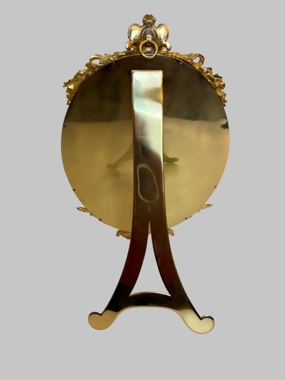 An oval late nineteenth-century French table mirror featuring a gilt bronze frame with blue champleve enamel scrollwork and ornate cast feet. View V