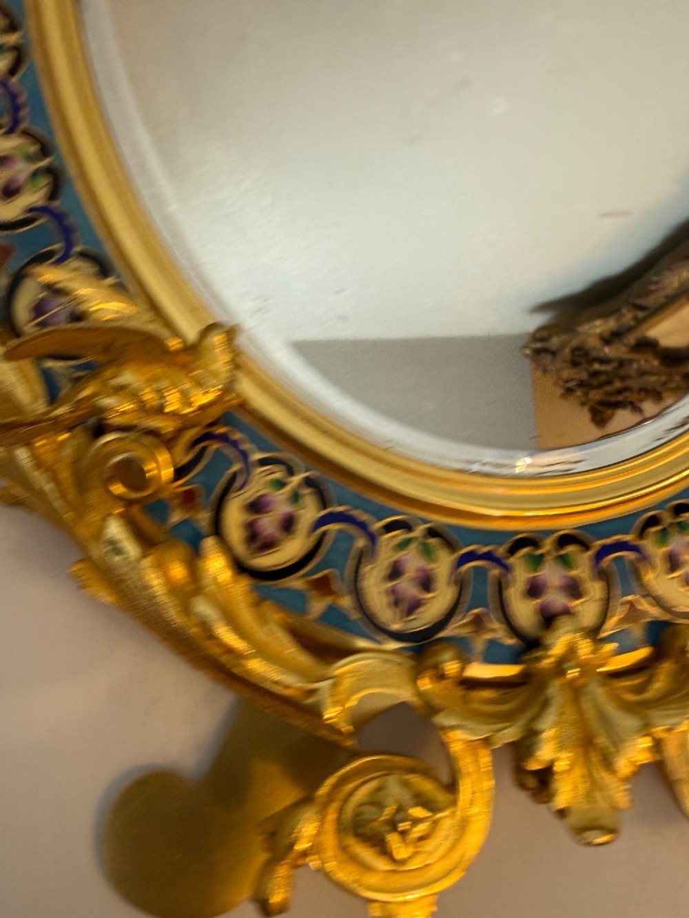 An oval late nineteenth-century French table mirror featuring a gilt bronze frame with blue champleve enamel scrollwork and ornate cast feet. View VII