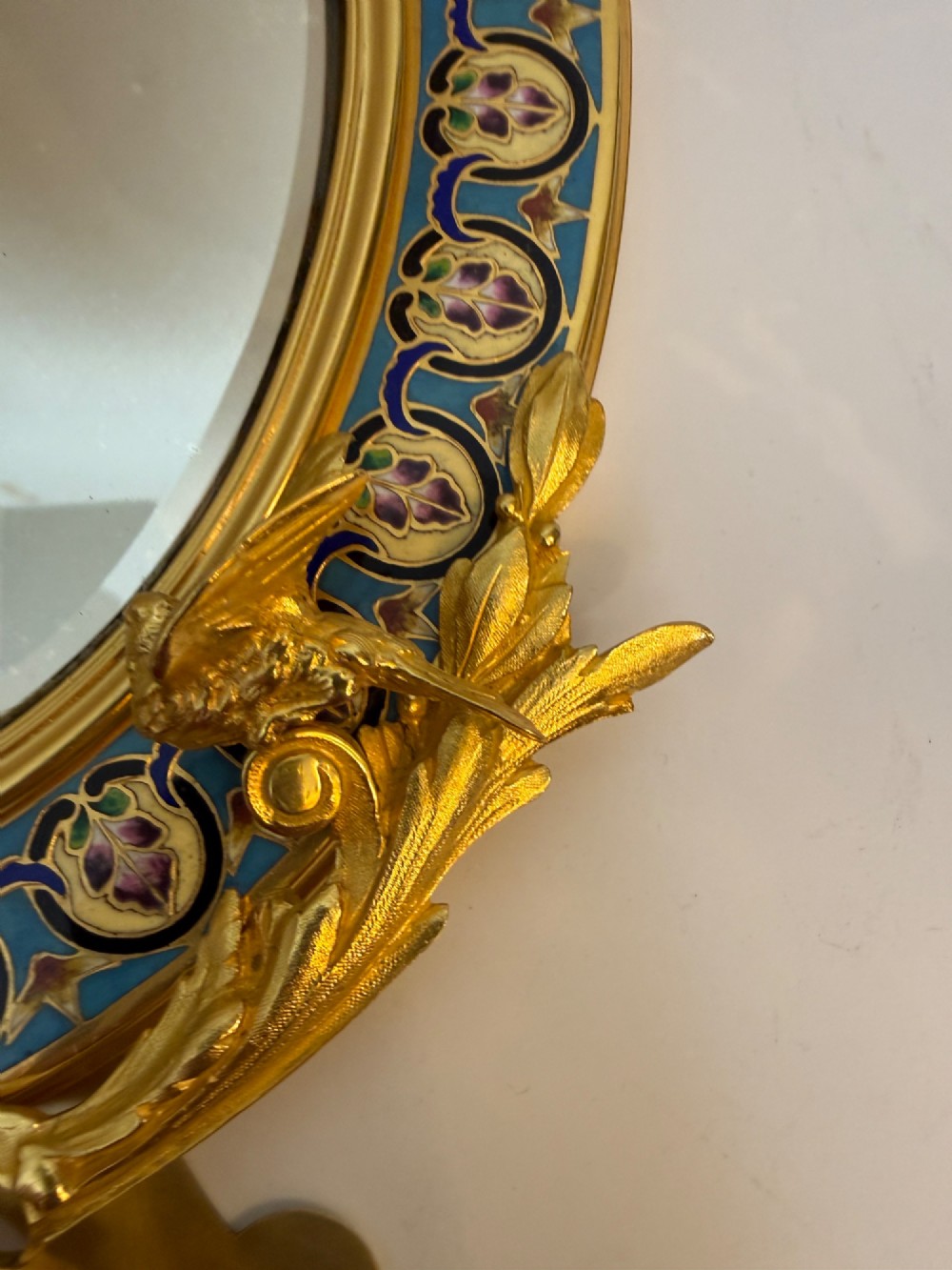An oval late nineteenth-century French table mirror featuring a gilt bronze frame with blue champleve enamel scrollwork and ornate cast feet. View VIII