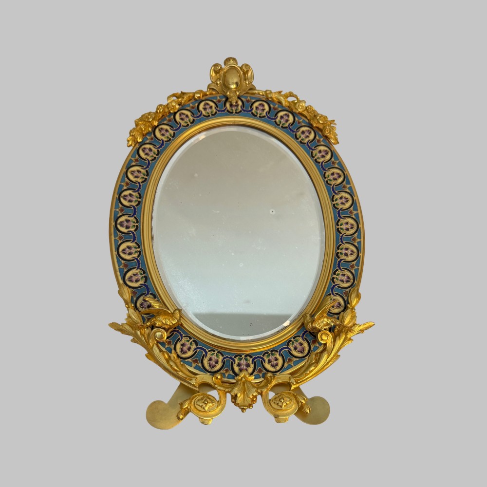 An oval late nineteenth-century French table mirror featuring a gilt bronze frame with blue champleve enamel scrollwork and ornate cast feet. View IX