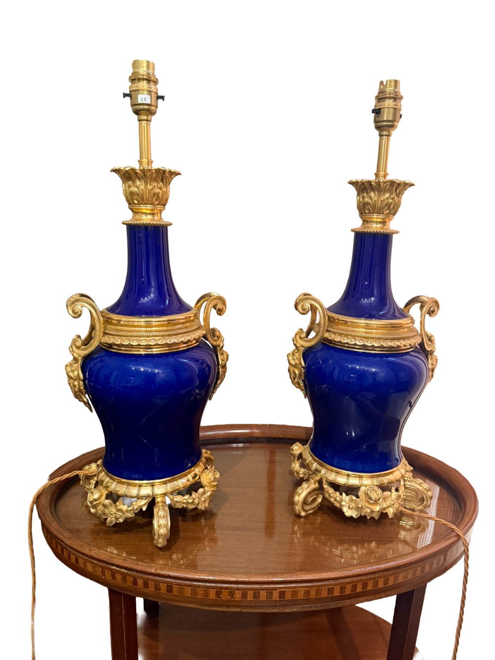 A pair of 19th-century French cobalt blue porcelain table lamps with gilt bronze ormolu mounts and scrolled handles.